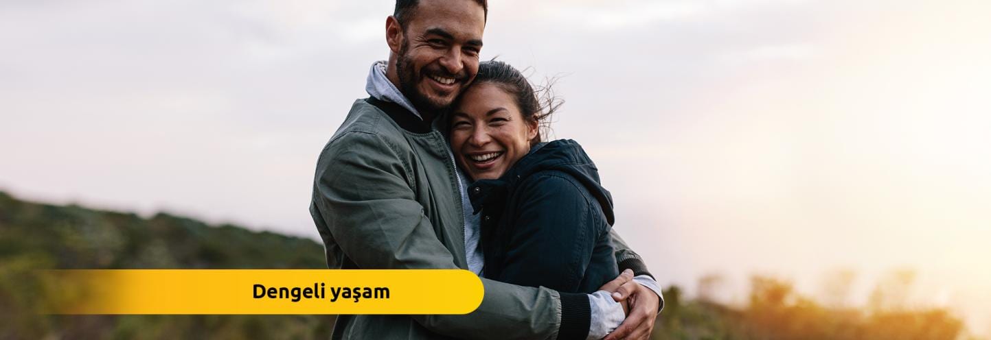 Kalın kıyafetler içinde gülümseyen çift